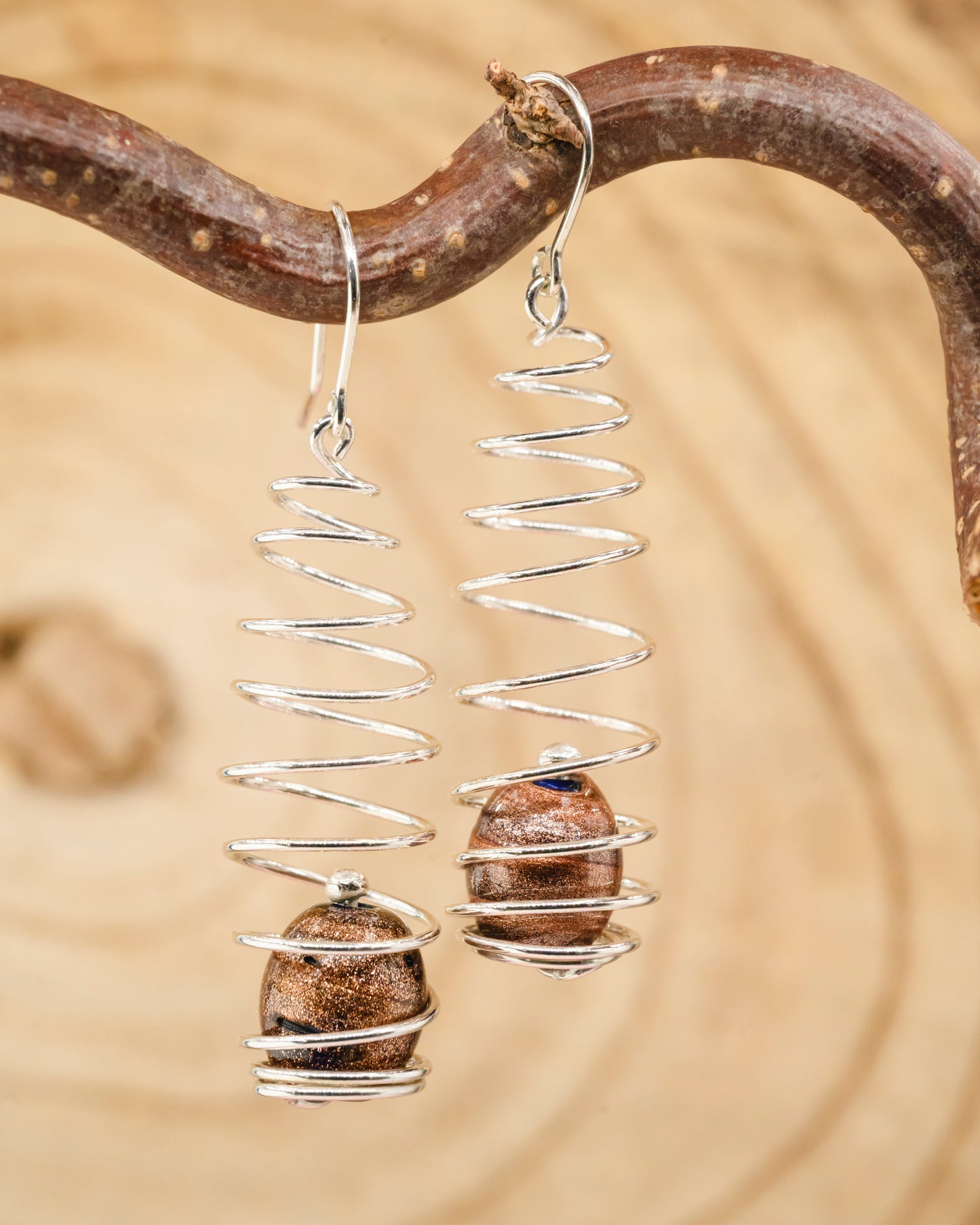 Long spiral earrings with brown glass beads