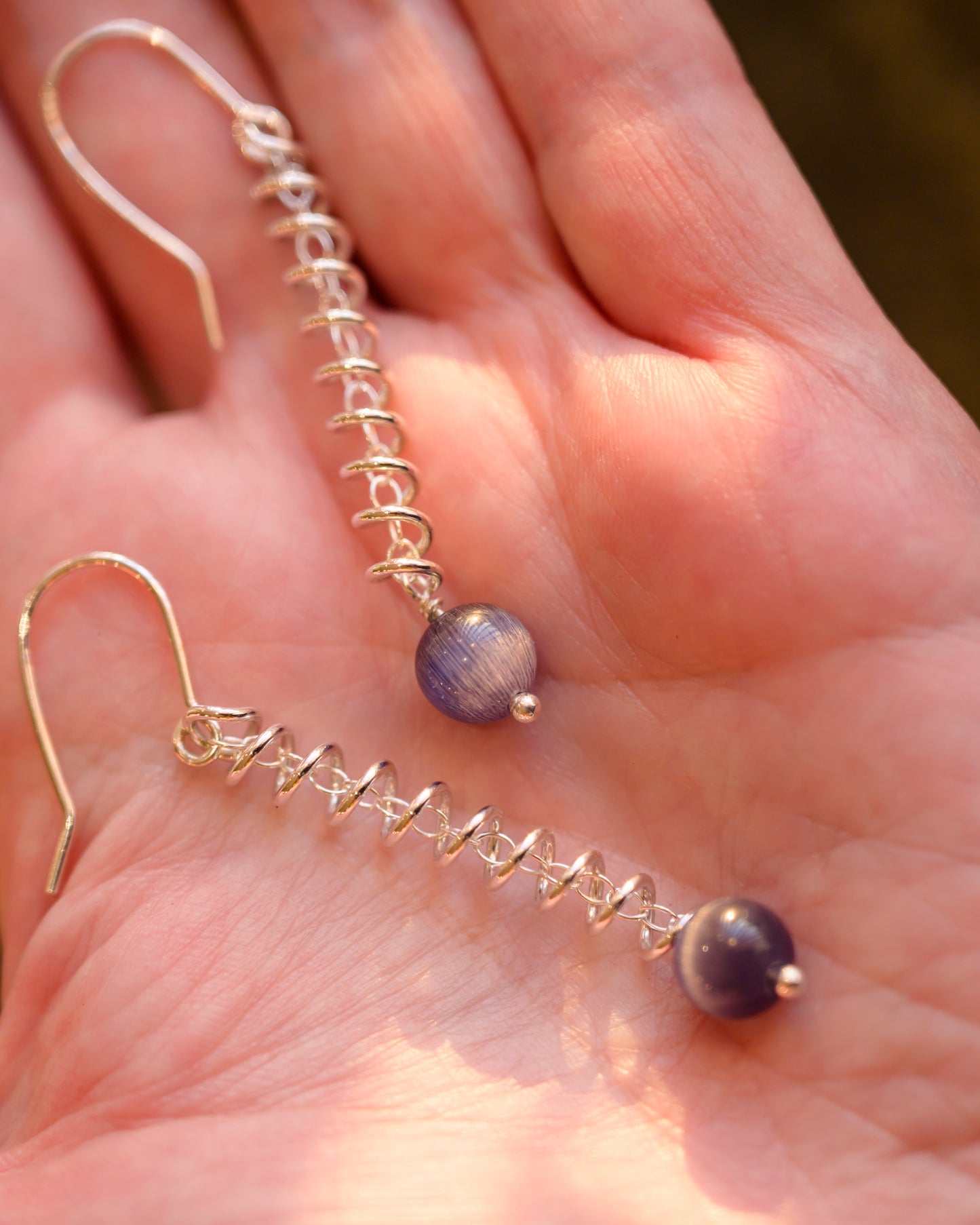 Narrow spiral earrings with purple cat's eye