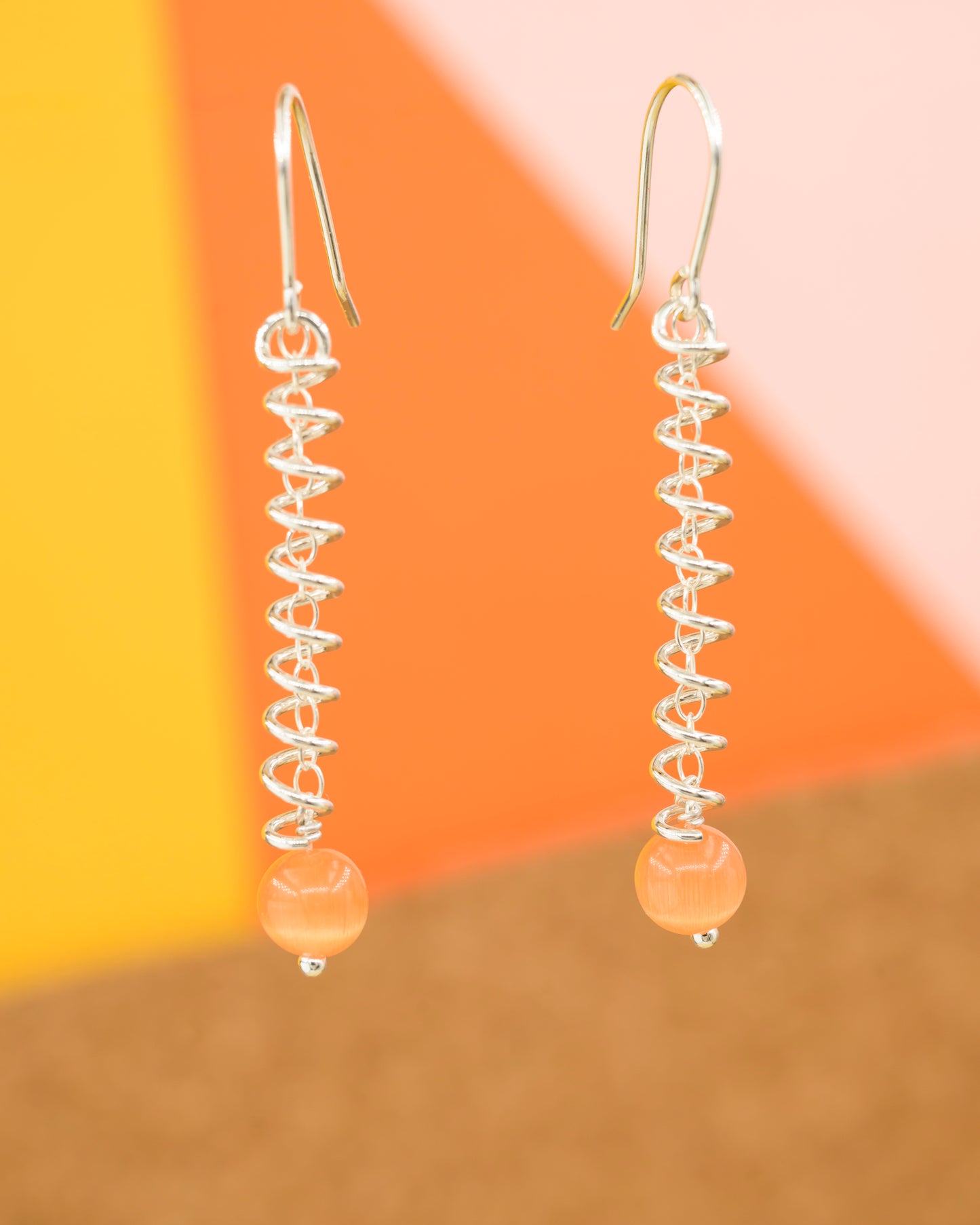 Narrow spiral earrings with orange cat's eye